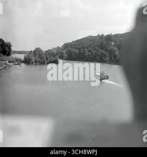 Eine dynamische Szene des Flusslebens am Sewerski Donets in Swiatohirsk in den 1970er-80er Jahren Der Rahmen zeigt verschiedene Schiffe, von Freizeitbooten und Flussbahnen voller Touristen bis hin zu schnellen Motorbooten, die sich vor der berühmten Landschaft der Heiligen Berge Lavra und Kreidehügel befinden. Das Foto vermittelt die Atmosphäre eines beliebten sowjetischen Resorts und ist ein anschauliches Zeugnis für den entwickelten Wassertourismus. Es ist ein nostalgisches Bild eines aktiven Sommerurlaubs und ein Symbol für das friedliche, unbeschwerte Leben im Donbass vor dem Krieg Stockfoto