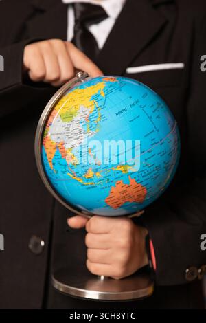 Eine Nahaufnahme der Hand eines Jungen auf einer Kugel. Der Junge hält eine Kugel. Nahaufnahme. Hochwertige Fotos Stockfoto