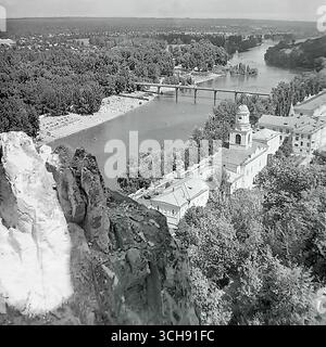 Ein herrlicher Panoramablick auf Sviatohirsk, von einer Kreidefelse in den 1970er-80er Jahren Die Aufnahme zeigt das berühmte architektonische Ensemble der Heiligen Berge Lavra (damals ein Sanatorium), den Seversky Donets Fluss, eine Brücke und einen überfüllten öffentlichen Strand. Dies ist ein klassisches Postkartenbild des Hauptortes Donbass, berühmt für seine einzigartige Natur. Das Foto ist ein kraftvolles und nostalgisches Symbol für Harmonie, Schönheit und ein friedliches, unbeschwertes Leben vor dem Krieg Stockfoto