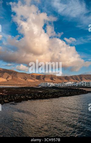Lanzarote: Blick auf Caleta de Famara, Fischerdorf im Nordosten, mit Risco de Famara, dem wichtigsten Bergmassiv der Insel, im Hintergrund Stockfoto