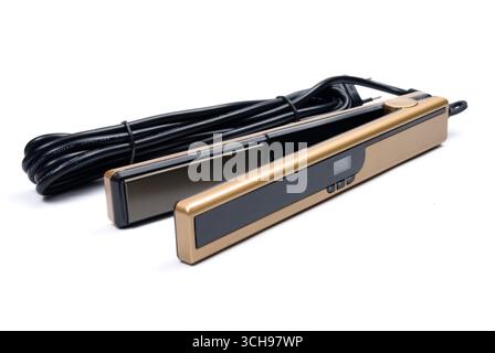 Goldener eletronischer Haarglätter auf weißem Hintergrund Stockfoto