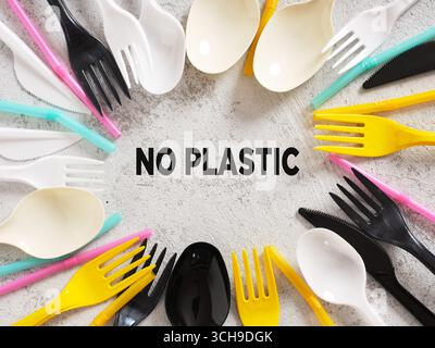 Buntes Plastikbesteck und Strohhalme umgeben den Begriff kein Plastik, fördern umweltfreundliche Alternativen und schärfen das Bewusstsein gegen Plastikpollu Stockfoto