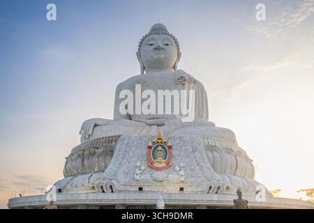 Weiße Marmor Big Buddha of Phuket Statue in meditativer Pose vor dem Himmel während Sonnenuntergang auf dem Gipfel des hohen Berges auf Phuket Island, Thailand Stockfoto