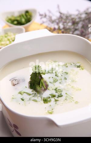 Milchfischsuppe mit Koriander in Keramikauflauf Stockfoto