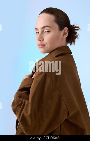 Eine junge Frau zeigt ihr stilvolles Outfit selbstbewusst in einem auffälligen Ambiente. Stockfoto