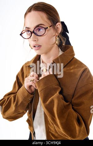 Eine junge, schöne Frau zeigt ihren einzigartigen Sinn für Mode und passt ihre stylische Jacke an. Stockfoto