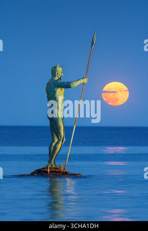 Statue des Neptun, der Trident hält, mit Vollmond-Dämmerung über dem Meereshorizont im Hintergrund, Strandresort-Komplex St. Konstantin und Helena, Var Stockfoto