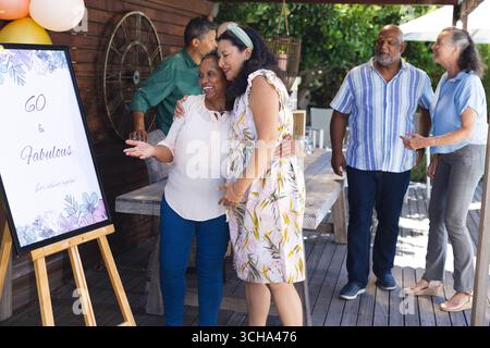 Geburtstagsparty im Freien, verschiedene Seniorenfreunde feiern Meilenstein mit Lachen und Freude. Feier, Spaß, verschiedene Seniorenfreunde, Glück, Gage Stockfoto