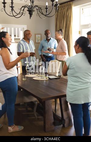 Afroamerikanische Seniorenfreunde genießen lebhafte Gespräche und Drinks zu Hause. Zusammengehörigkeit, Sozialisierung, Vielfalt, Gruppe, Freund Stockfoto