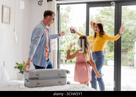Familie feiert Urlaub, packt Koffer zu Hause, begeistert von Reiseabenteuer. Begeisterung, Vorbereitung Stockfoto