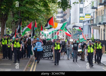 Pro-Palästina-Protest marschiert durch ein Wohngebiet von Southend on Sea, Essex, Großbritannien. Polizeibeamte führen Stockfoto