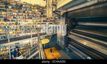 Buchhandlung Ler Devagar in Lissabons LX Factory, einer ehemaligen Zeitungsdruckerei, heute kultureller Hotspot, mit Büchern, Schallplatten und historischen Maschinen. Stockfoto