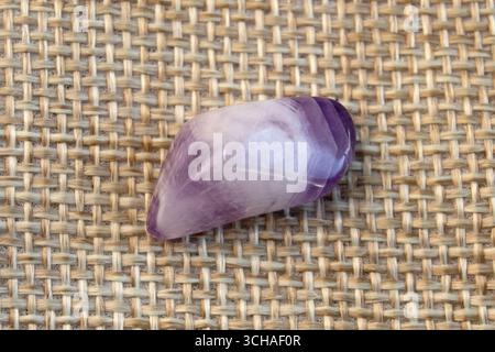 Set aus verschiedenen natürlichen Amethyst-Mineralsteinen und Edelsteinen auf violettem Hintergrund, teilweise fokussiert von oben Stockfoto
