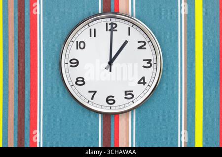 Bürouhr zeigt eine Uhr an einer farbenfrohen Wand Stockfoto