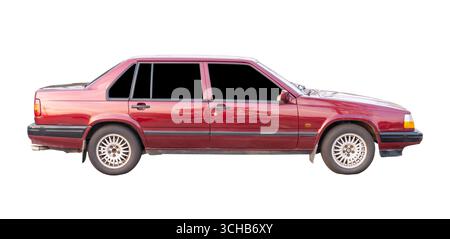 Die rechte Seitenansicht des alten Modells einer roten Sportlimousine am Horizont ist auf weißem Hintergrund mit dem Beschneidungspfad isoliert. Stockfoto