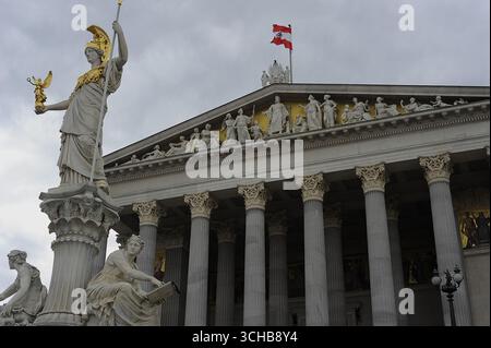 Elegante Außenansicht des österreichischen Parlaments in Wien mit der berühmten Pallas Athena-Statue im Vordergrund – ein Symbol für Weisheit und Demokratie Stockfoto