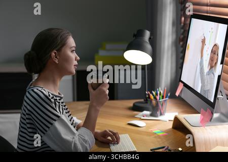 E-Learning-Konzept. Schüler, der Online-Videochat mit dem Lehrer über einen Computer am Schreibtisch führt Stockfoto