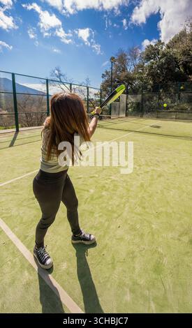 Eine junge, starke, athletische Frau, die auf einem Bergplatz im Freien Paddle-Tennis spielt. Stockfoto