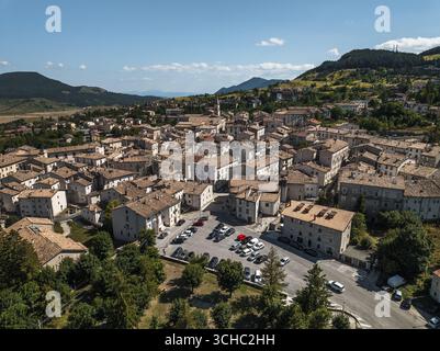 Blick aus der Vogelperspektive auf die malerische Stadt, eingebettet in sanfte Hügel, mit der zentralen piazza, die unter den alten Kirchtürmen thront, Pescocostanzo, Abruzzen, Italien. Stockfoto