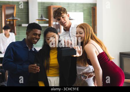 Teen verschiedene Freunde lachen und machen Selfie zu Hause während der Feier. Freundschaft, Glück, Verbundenheit, Lebensstil, freudig, Freizeit Stockfoto