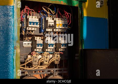 Stromverteilereinheit mit Sicherungskasten oder Leistungsschalter in einem alten Industriegebäude. Spannungsschalttafel mit Leistungsschaltern. E Stockfoto