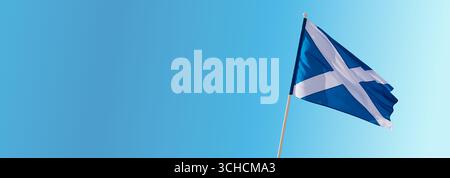 Die Nationalflagge Schottlands, das Saltyre oder St. Andrew’s Cross, fliegt auf einem Fahnenmast vor einem blauen Himmel mit verstreuten Wolken und symbolisiert Schottisch Stockfoto