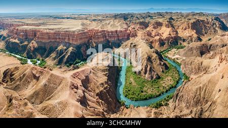Panoramablick auf den Charyn Canyon mit seinen bunten Felsformationen und den Sharyn River, der sich durch die Landschaft Kasachstans schlängelt Stockfoto