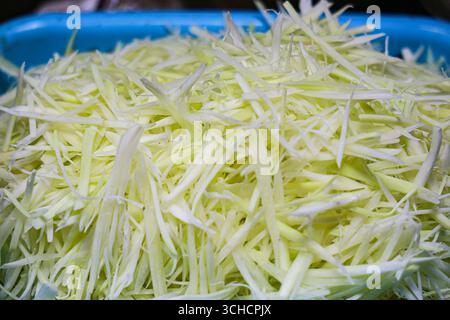 Frisch gehackte Papaya auf Tablett, wichtige Zutat für Thai-Som-Tam-Salat. Beliebt auf Street Food Märkten und asiatischer Küche. Stockfoto