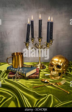 Zeitgenössische Vanitas-Komposition mit einem menschlichen Schädel auf kastanienbraunem Samt neben einem silbernen Kandelaber mit geschmolzenen Kerzen Stockfoto
