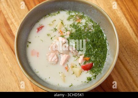 Dies ist eine köstliche und cremige Lachssuppe, angereichert mit frischen Kräutern und lebendigem Gemüse Stockfoto