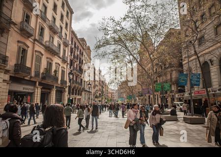 BARCELONA, SPANIEN - 5. APRIL 2025: Menschenmassen entlang der Las Ramblas in Barcelona, einer Fußgängerstraße mit historischen Gebäuden. Die Szene zeigt Touristen und Stockfoto