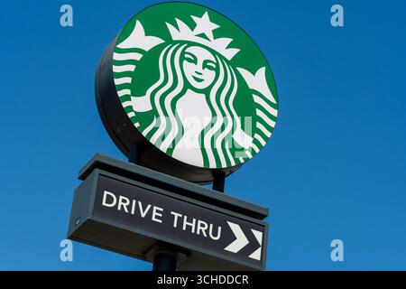 Provo, Utah, USA – 1. September 2025: Ein Starbucks-Schild am Straßenrand markiert den Drive-Thru-Eingang, mit einem Richtungspfeil, der die Fahrzeuge nach rechts führt. Stockfoto