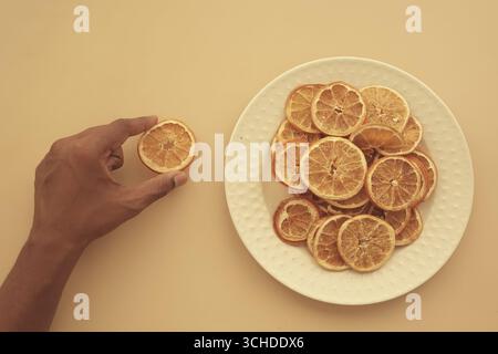 In Scheiben geschnittene getrocknete Zitrusfrüchte auf einem Teller angeordnet Stockfoto