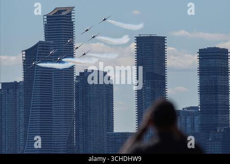 Nicht exklusiv: Die Kanadischen Streitkräfte Snowbirds in ihrer charakteristischen Formation, die vor der atemberaubenden Kulisse der Skyline von Toronto aufsteigen. Die Preci Stockfoto