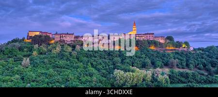 Panoramablick auf die mittelalterliche Stadt Buzet, auf einem Hügel gelegen, bei Nacht. Stockfoto
