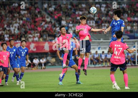 Spieler beider Teams kämpfen während des Spiels heftig. Zhenjiang, China, 31. August 2025. Die neue Runde der Jiangsu City Football League 2025 (Su Chao) begann am Abend des 31. August 2025 in der Stadt Zhenjiang, Provinz Jiangsu. Junge Fans schoben einen riesigen Fußball, um vor dem Spielbeginn eine Aufwärmphase zu machen, was eine lebhafte Atmosphäre auf dem Spielfeld schafft. Quelle: Yang Bo/China News Service/Alamy Live News Stockfoto