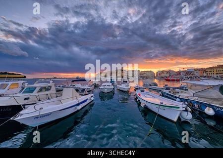 Häuser in der Küstenstadt Rovinj und der Glockenturm der St. Euphemia-Kirche, über den Booten, die bei Sonnenuntergang im Jachthafen ankern. Rovinj Istrien Stockfoto