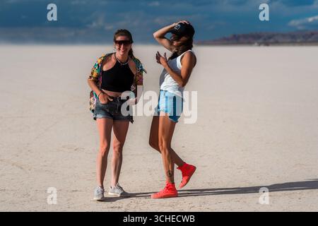 Argentinische Touristen beobachten, wie Yachtpiloten über das trockene Seebett von Barreal Blanco in der argentinischen Provinz San Juan fahren. Stockfoto