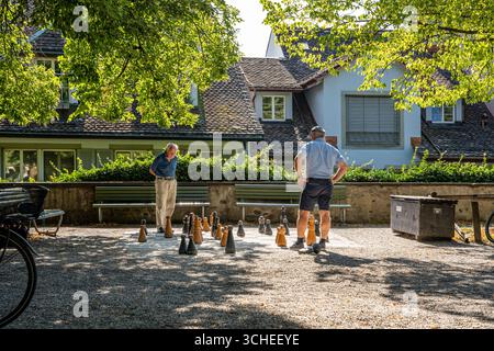 Zwei ältere Männer spielen lebensgroßes Schach im Park des historischen Lindenhofs belvedere, ein beliebtes Kulturdenkmal in Zürich. Stockfoto