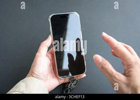 Hände halten und das Telefon durchsuchen. Nahansicht. Stockfoto