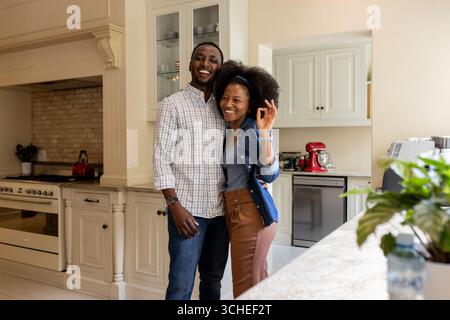 Glückliches Paar, das sich in der Küche umschließt und zu Hause eine gute gemeinsame Zeit genießt Stockfoto