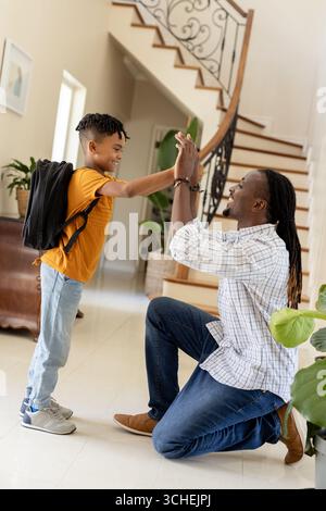 Afroamerikaner Vater und Sohn sind zu Hause High Five, feiern Schultag Stockfoto