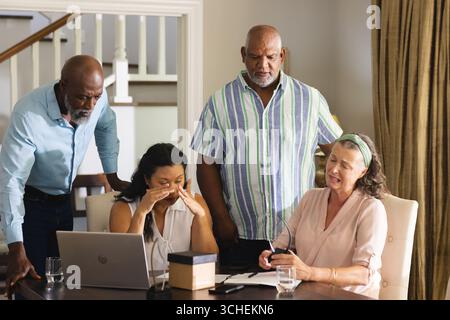 Die Finanzen zu Hause besprechen, die leitende Gruppe kümmert sich um Laptop und Dokumente Stockfoto