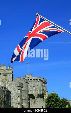 Windsor Castle in England Großbritannien mit einer Union Jack Flagge im Vordergrund, die 1066 von William dem Eroberer gebaut wurde Stockfoto