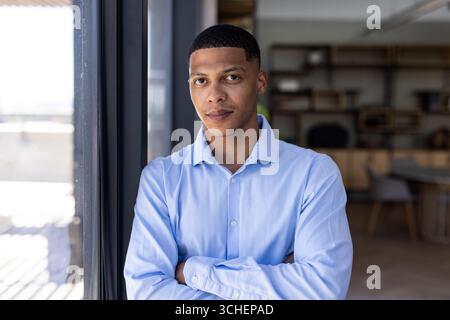 Selbstbewusster Mann in blauem Hemd, der im modernen Büro steht, Kopierraum Stockfoto