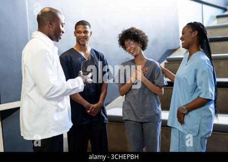 Medizinische Fachkräfte in der Scrubs lächeln und diskutieren im Krankenhaus, im Konferenzsaal Stockfoto
