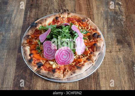 Sheffield, Großbritannien 12. März 2020: Köstliche handwerkliche vegane Pizza mit frischen Raketenblättern und eingelegtem Gemüse von Fools Gold Pizza Stockfoto