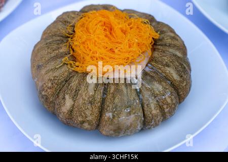 Kürbis Vanillepudding. Traditionelle thailändische Dessert. Mix Eier mit Zucker, Kokosmilch, pandan und in die vorbereiteten Kürbis und Dampf gießen die gefüllten Kürbis hig Stockfoto