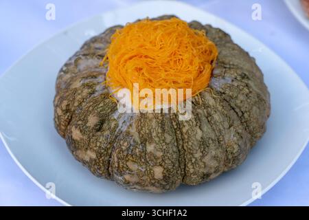 Kürbis Vanillepudding. Traditionelle thailändische Dessert. Mix Eier mit Zucker, Kokosmilch, pandan und in die vorbereiteten Kürbis und Dampf gießen die gefüllten Kürbis hig Stockfoto