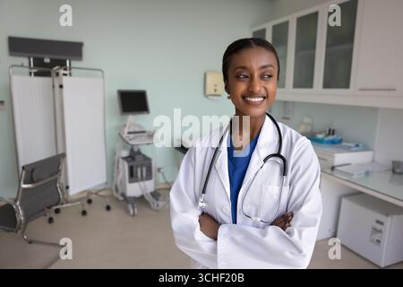 Gesundheitsfacharzt posiert mit überkreuzten Armen im modernen Untersuchungsraum Stockfoto